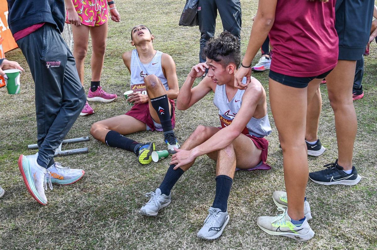 Benjamin Fernandez, left, and Hunter Hannah of Matilda Torres High rest after finishing their Central Section boys Division IV cross country race at Woodward Park in Fresno on Thursday, Nov. 17, 2022. Fernandez finished first and Hannah fourth while the team finished first overall.