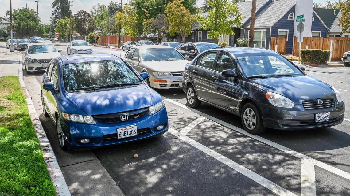 Cars parked in both the bike lane, left, and designated parking spaces on Van Ness Avenue where it turns into Maroa near Fresno City College show just how confused people are about the new bike lane layout, on Tuesday, Sept. 20, 2022.