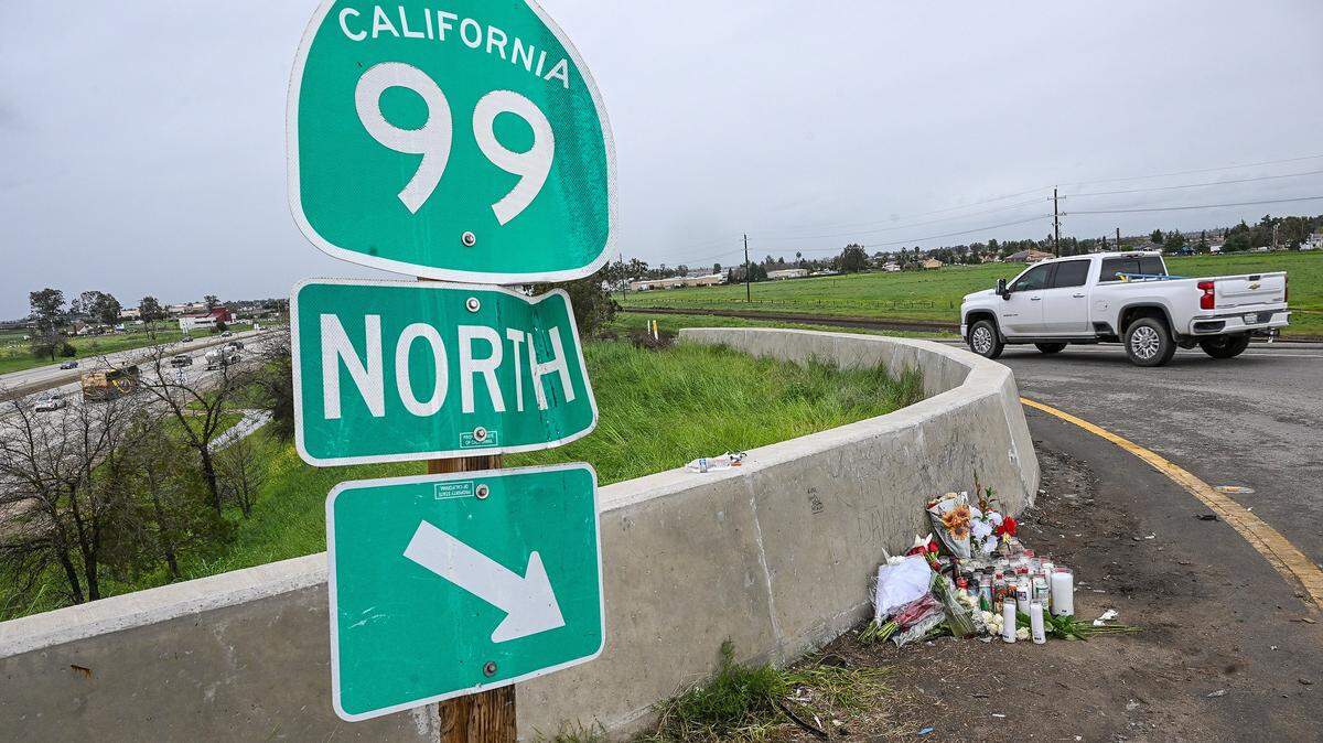 A memorial with candles and flowers has been appears on Tuesday, Feb. 17, 2026 at the site of a crash that killed four people early Sunday morning near the freeway onramp at Highway 99 and Avenue 17 in Madera County.