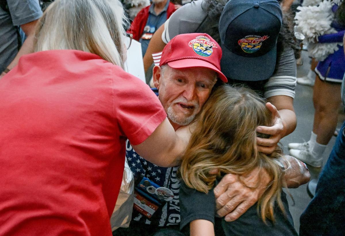Vietnam War veteran Patrick Galle, center, of Clovis, gets a hug from his wife, Linda, his daughter Andrea Crow and granddaughter Violet Crow as he arrives back at Fresno Yosemite International Airport to a heroes welcome on Wednesday, May 17, 2023.