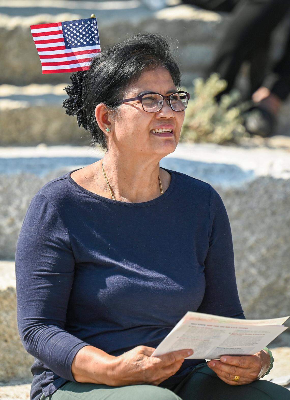 Mom Meas, an immigrant from Cambodia and current resident of Friant, wears an American flag in her hair during a naturalization ceremony held at Glacier Point in Yosemite National Park on Wednesday, Sept. 17, 2025.