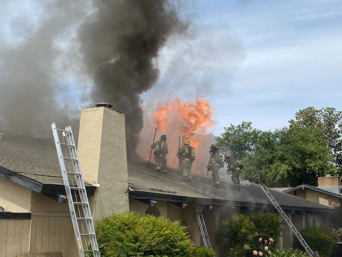 Flames shoot from the roof of an apartment on Argyle Avenue in southeast Fresno on Thursday, March 14, 2022.