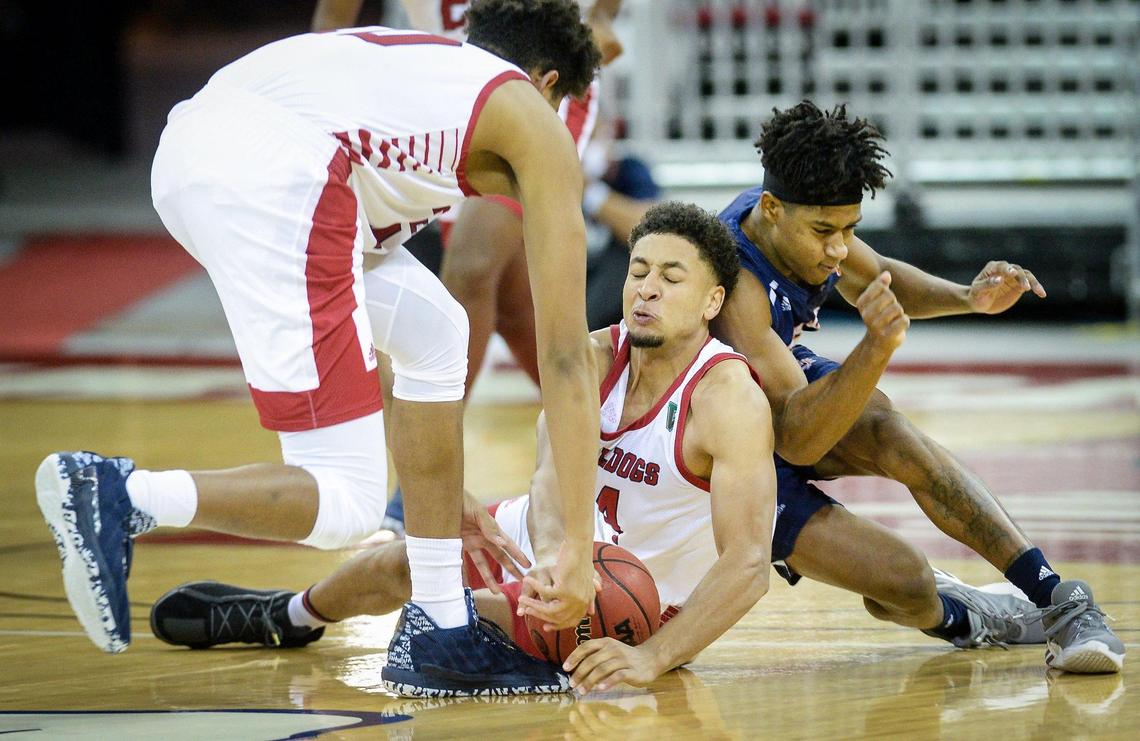 Fresno State’s Junior Ballard, center, falls on a loose ball while getting help from teammate Orlando Robinson as Fresno Pacific’s Raine McKeython collides with him in their game at the Save Mart Center in Fresno on Saturday, Dec. 19, 2020.