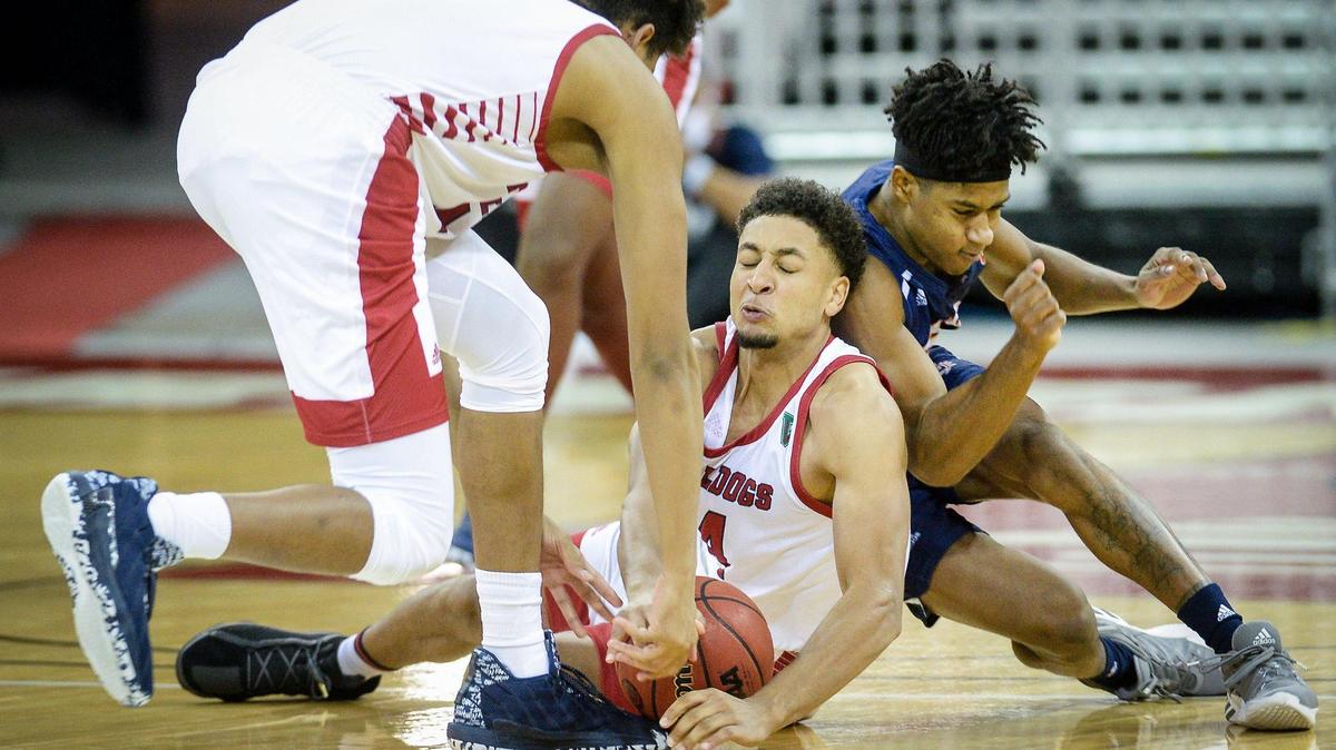 In a file photo, Fresno State’s Junior Ballard, center, falls on a loose ball while getting help from teammate Orlando Robinson in a 2020 game. Ballard’s return to the Bulldogs Tuesday, Feb. 1, 2022 at San Jose State was a much-needed boost.