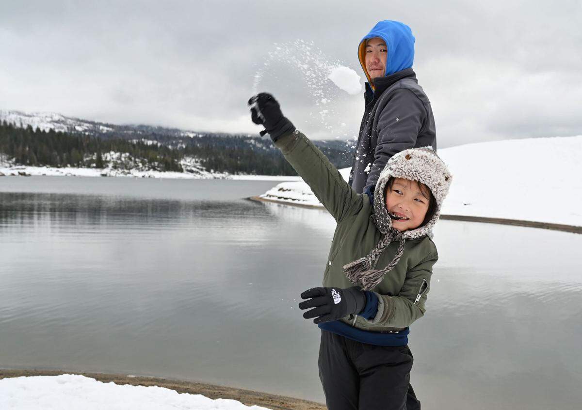 Orion Vu, 5, of Fresno throws a snowball while playing with his dad Lelick Vu at Shaver Lake on Monday, Dec. 12, 2022.