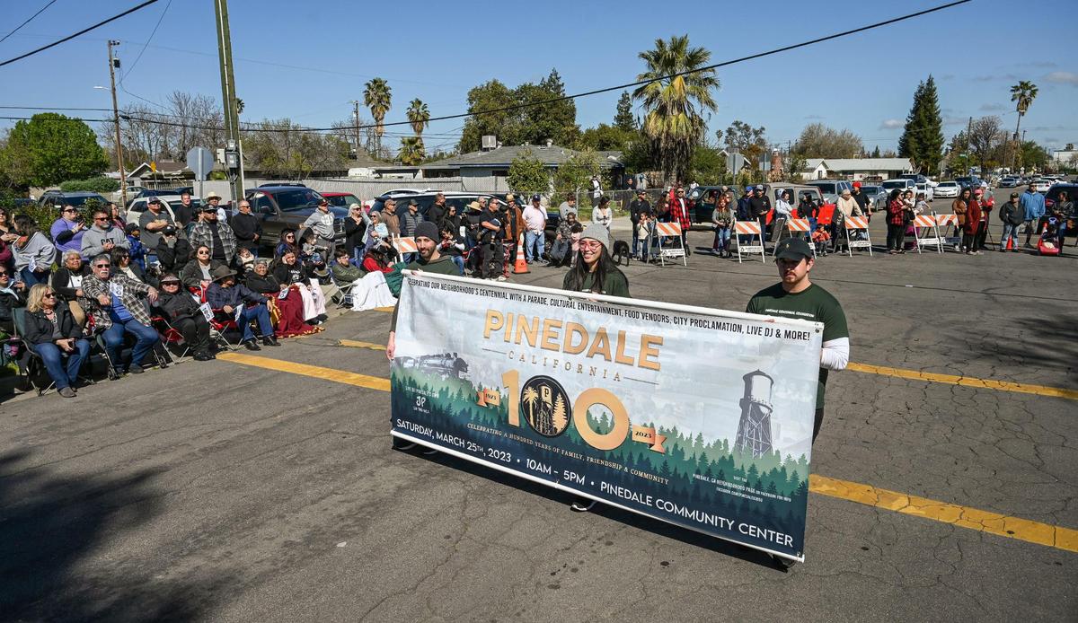 Parade participants carry Pinedale’s centennial banner to start the parade for the community’s centennial celebration outside the Pinedale Community Center on Saturday, March 25, 2023. The community in north Fresno is celebrating the 100th anniversary of its establishment.