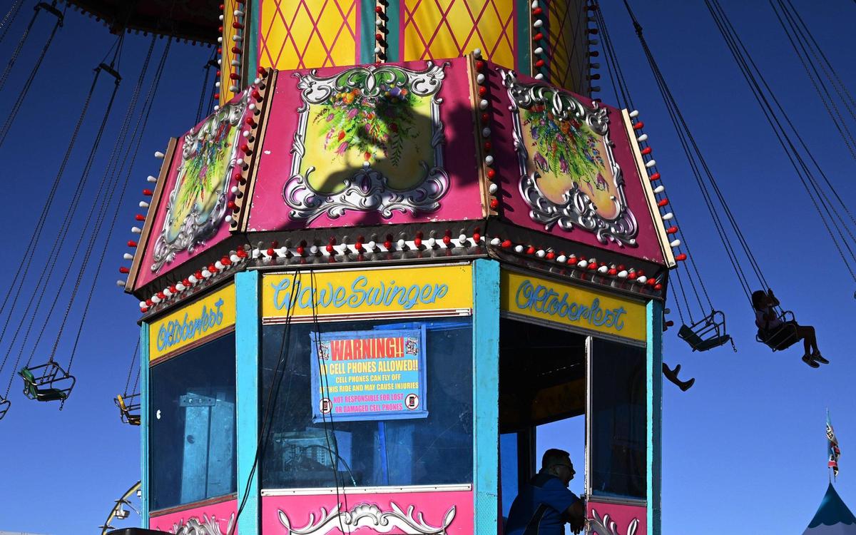 The operator yawns while riders spin on the Oktoberfest Wave Swinger as the 2022 Big Fresno Fair holds its opening day Wednesday, Oct. 5, 2022 in Fresno. The Fair returns October 5-16 with food, entertainment, exhibits and the Midway rides and games.