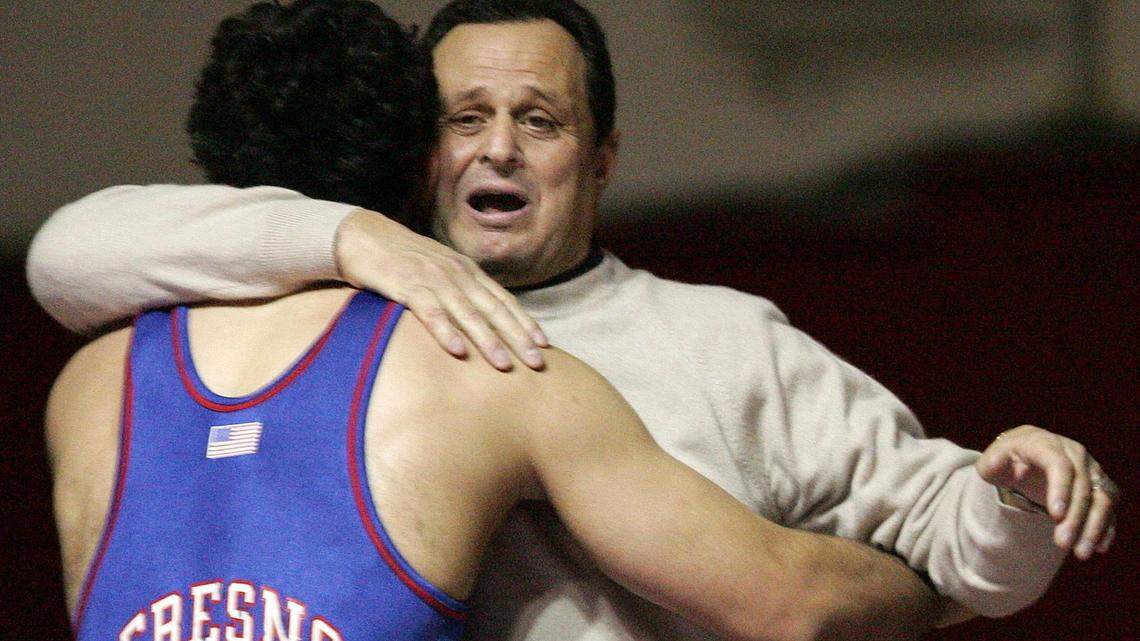 Fresno State wrestling coach Dennis Deliddo gets a hug from wrestler Marcio Botelho during Deliddo’s final home match against Bakersfield Wednesday Feb 9,2004.