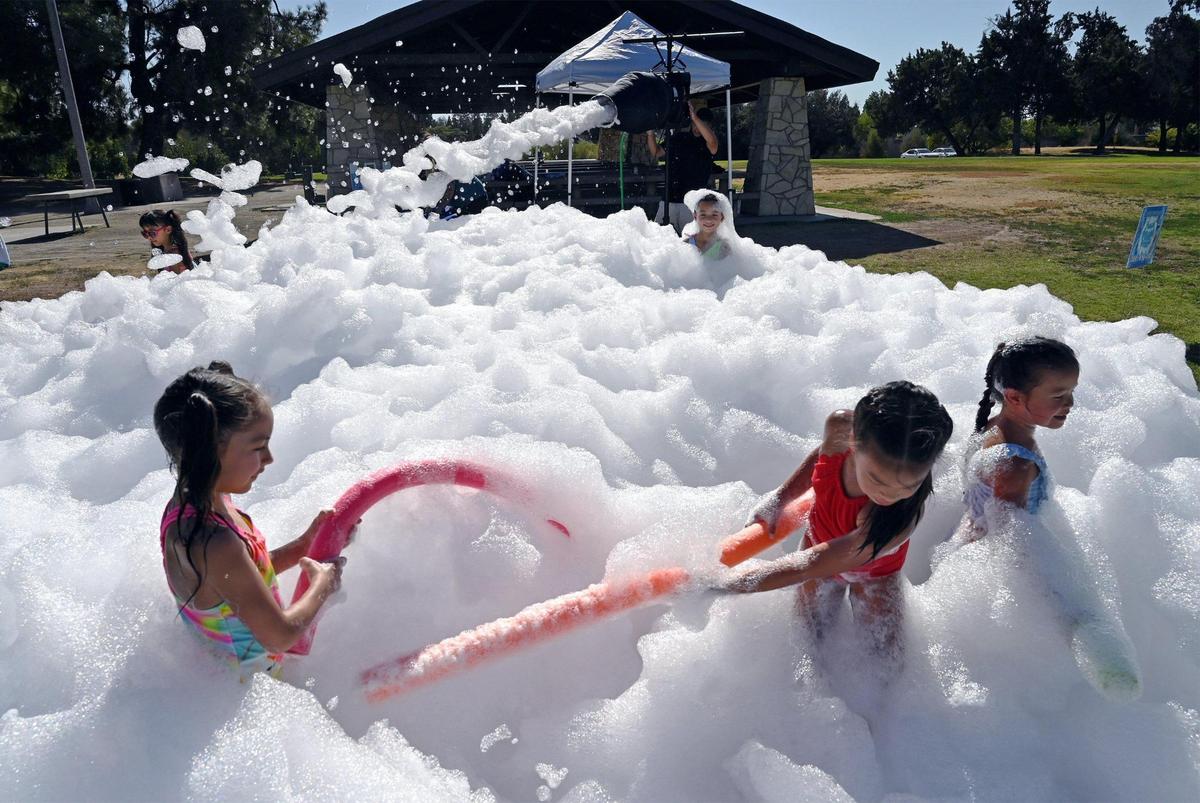 Children play in foam demonstrated by Fresno Foam Party at Woodward Park Friday, Aug. 19, 2022 in Fresno. Fresno Foam Party, formed in July, is a company that offers a unique and fun foam experience for parties and other gatherings.