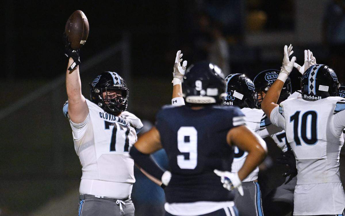 Clovis North's Jackson Reilly raises the ball after he recovered a fumbled punt for a touchdown against Redwood High Friday, Aug. 29, 2025 in Visalia. Clovis North held off Redwood for a 38-34 win.