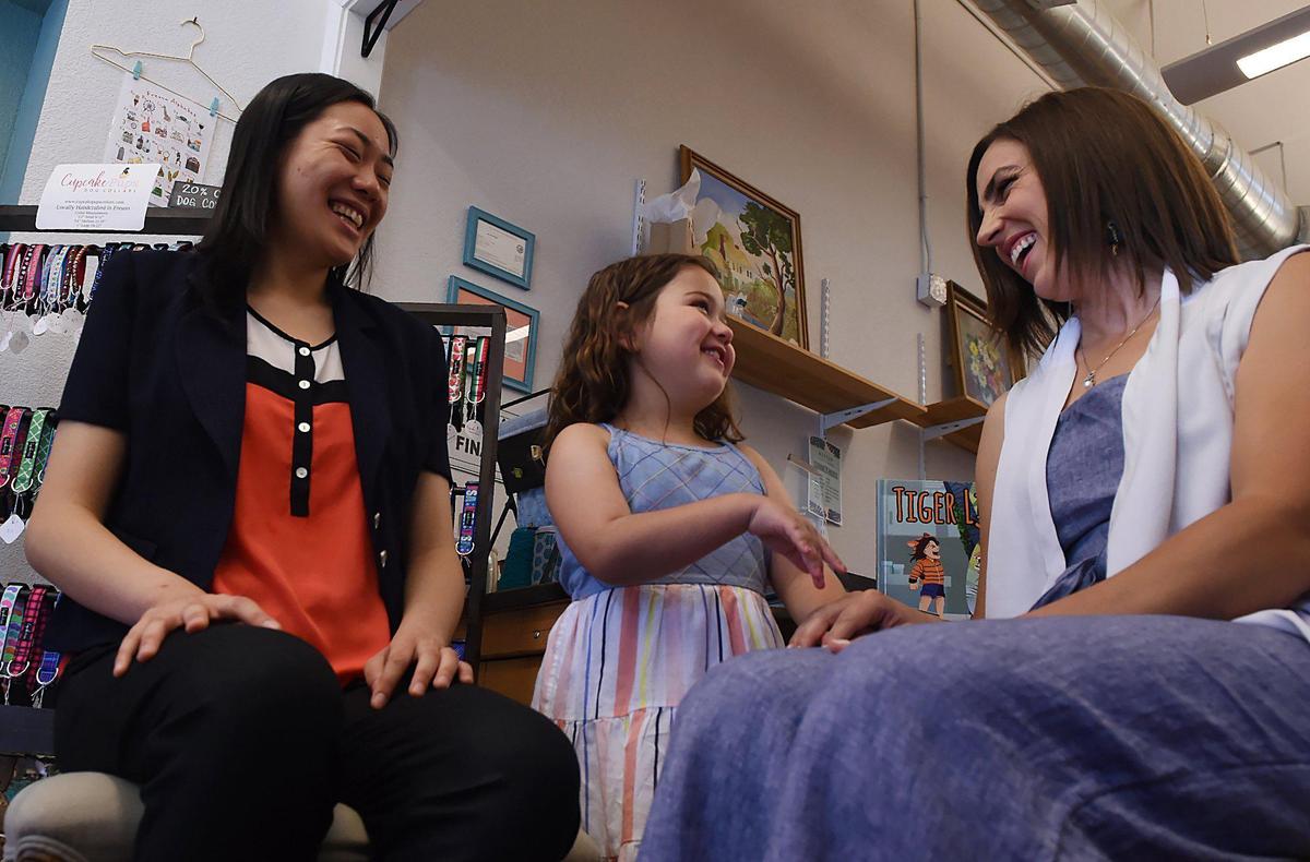 Livy Garcia, 7, center, laughs with her aunt Erin Garcia, right, with Clovis North student Ivreese Tong, 16, to the left, at Vivily Vintage & Handmade Friday, June 28, 2019 in Fresno. Erin Garcia co-authored an inspirational book, illustrated by Tong, based on Livy Garcia’s struggle with juvenile dermatomyositis.