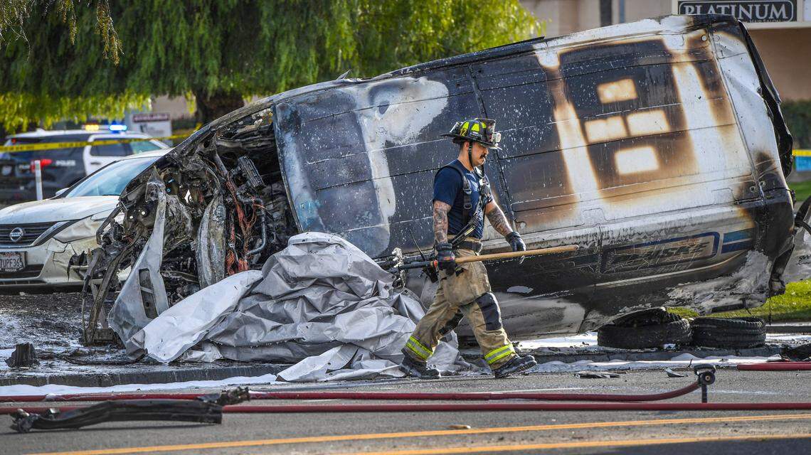 A Fresno firefighter walks by a van that was involved in a fatal crash after a brief police chase at the intersection of Bullard and West avenues in Fresno on Thursday, March 11, 2021.