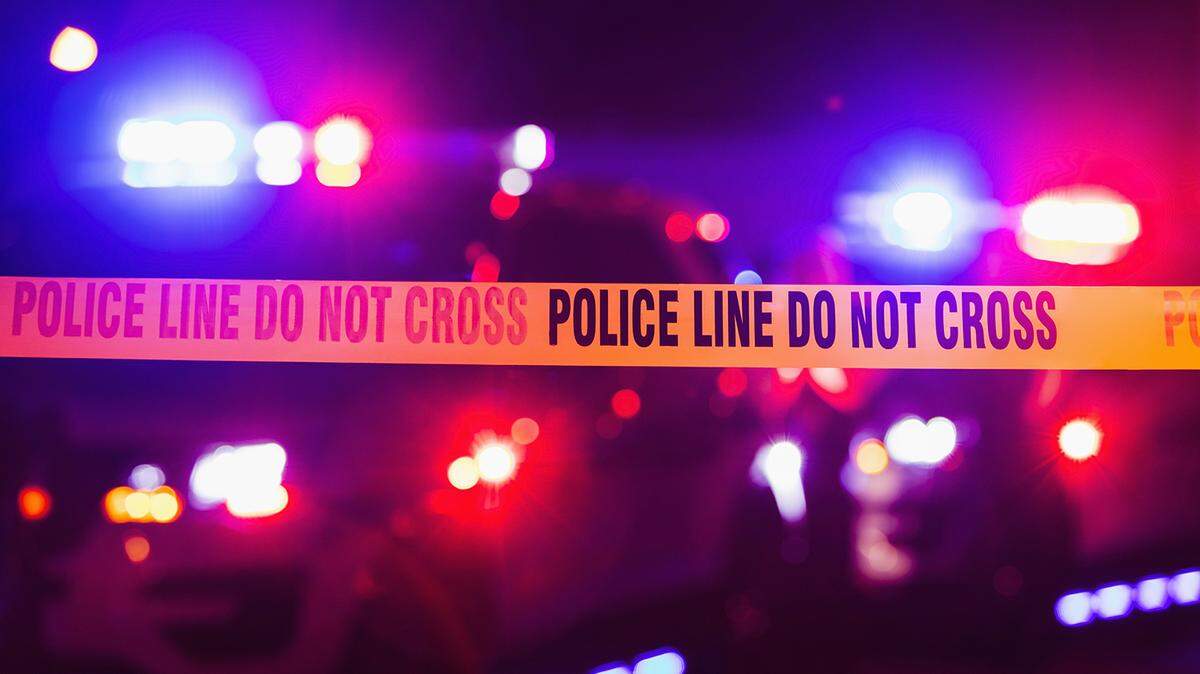 File photo of police tape with police lights in the background