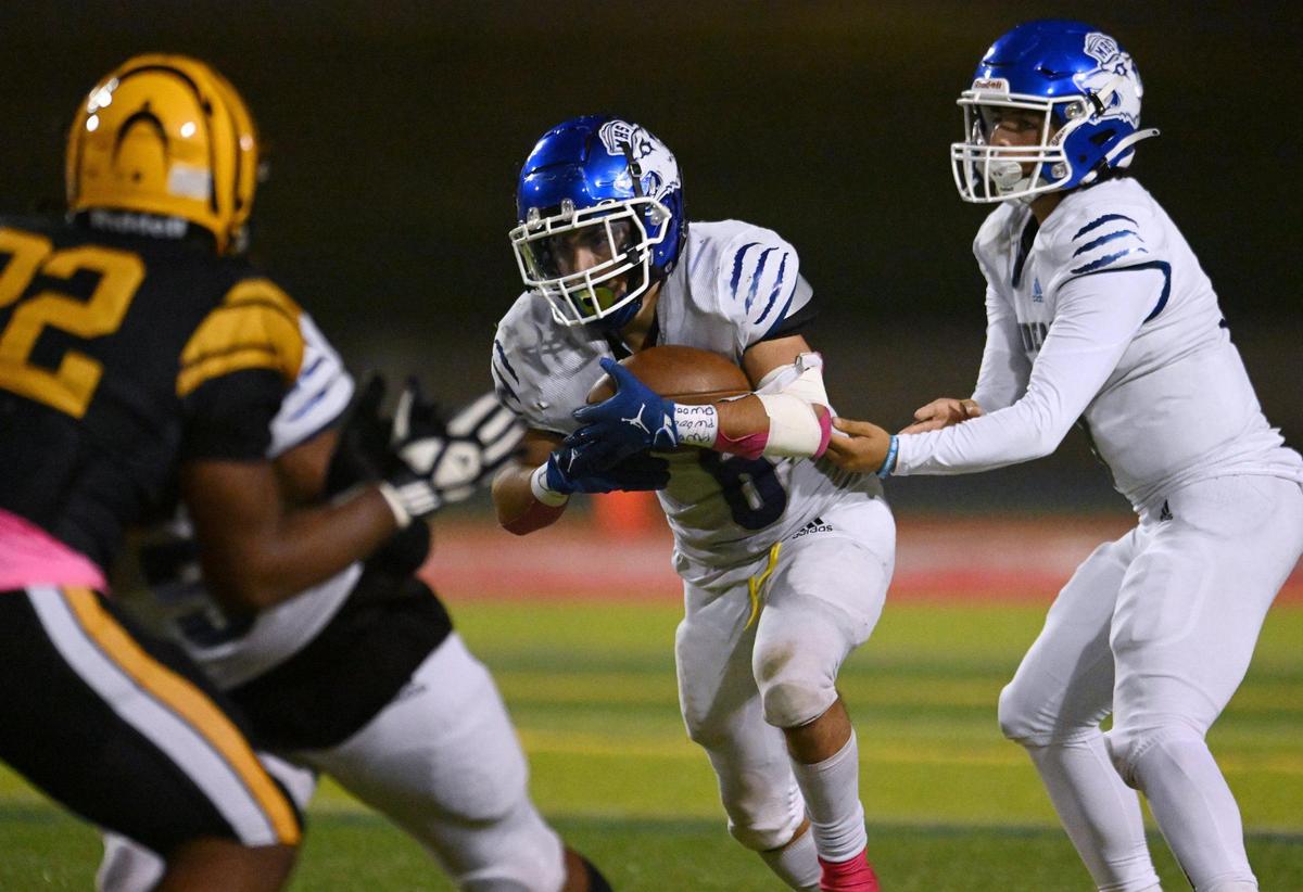 Madera quarterback Joel Arellano, right, hands off to Daniel Mendez, center, in a run against Edison Friday, Oct. 20, 2023 in Fresno.