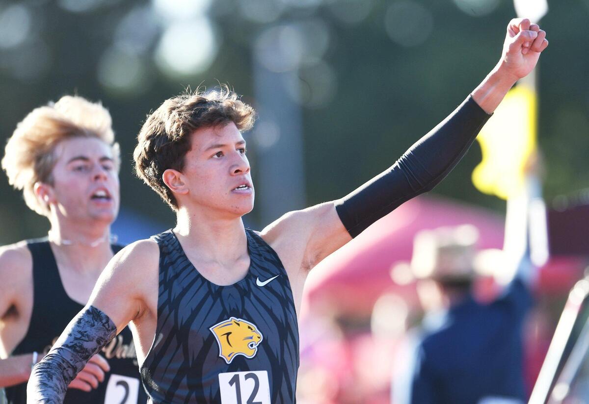 Clovis High’s Christopher Caudillo raises his first at the timing board as he places first in the Boys 1600m Run at the CIF State Track and Field Championship finals Saturday, May 28, 2022 in Clovis.