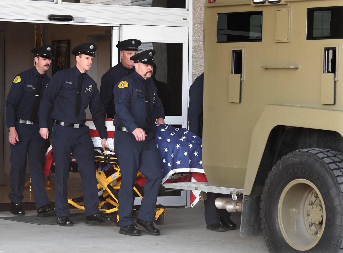 The flag-draped casket of Joey De Anda, a Santa Barbara County firefighter, paramedic and SWAT team member from San Luis Obispo, is conveyed via a gurney by fellow firefighters to a Santa Barbara County Sheriff Department tactical SWAT vehicle called the Bearcat, to begin his procession back to the Central Coast, from the Fresno County Coroner’s Office, Tuesday, Jan. 11, 2022. De Anda died in a weekend snowboarding accident at China Peak Mountain Resort. Dozens of members of firefighting units were present in honor of De Anda. The transport via the Bearcat was in tribute to his service as a SWAT member.