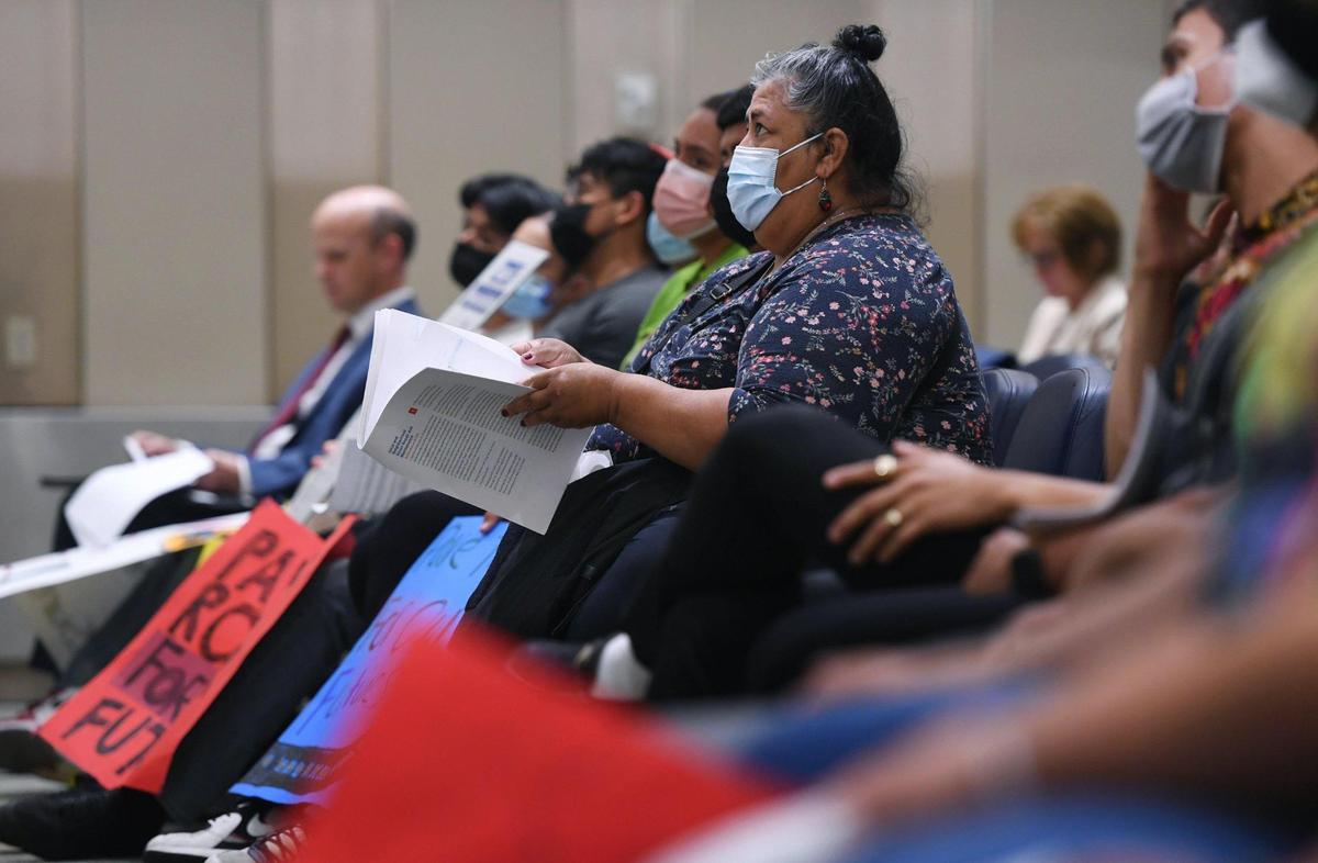 Lourdes Medina, center, looks up at the projected screen as she and others listen at the Fresno Council of Governments (COG) which met at Fresno City Hall to hear public comments and then vote to put an initiative to renew Measure C on the ballot this fall Thursday, July 7, 2022 in Fresno.
