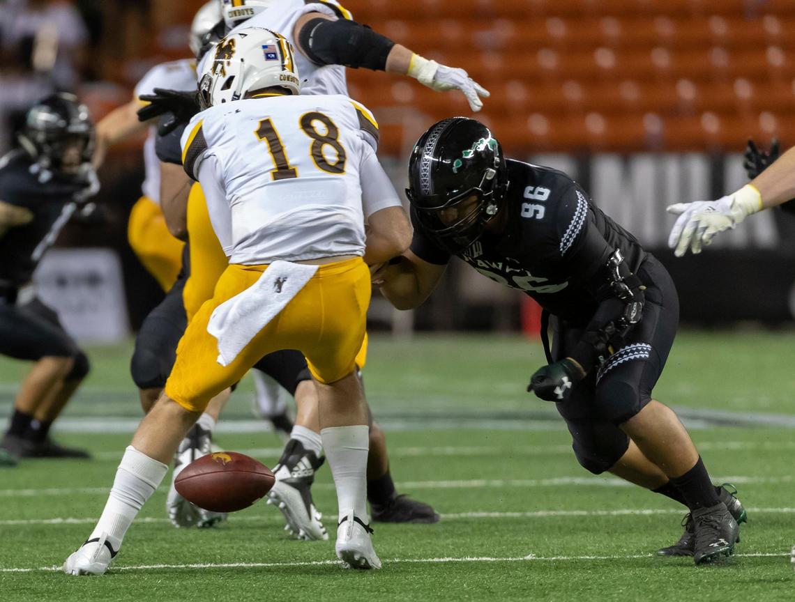 Hawaii defensive end Kaimana Padello (96) strips the football away from Wyoming quarterback Tyler Vander Waal (18) in the first half of the Rainbow Warriors’ 17-13 victory over the Cowboys, Saturday, Oct. 6, 2018, in Honolulu. Padello is leading the Mountain West with 7.0 sacks.
