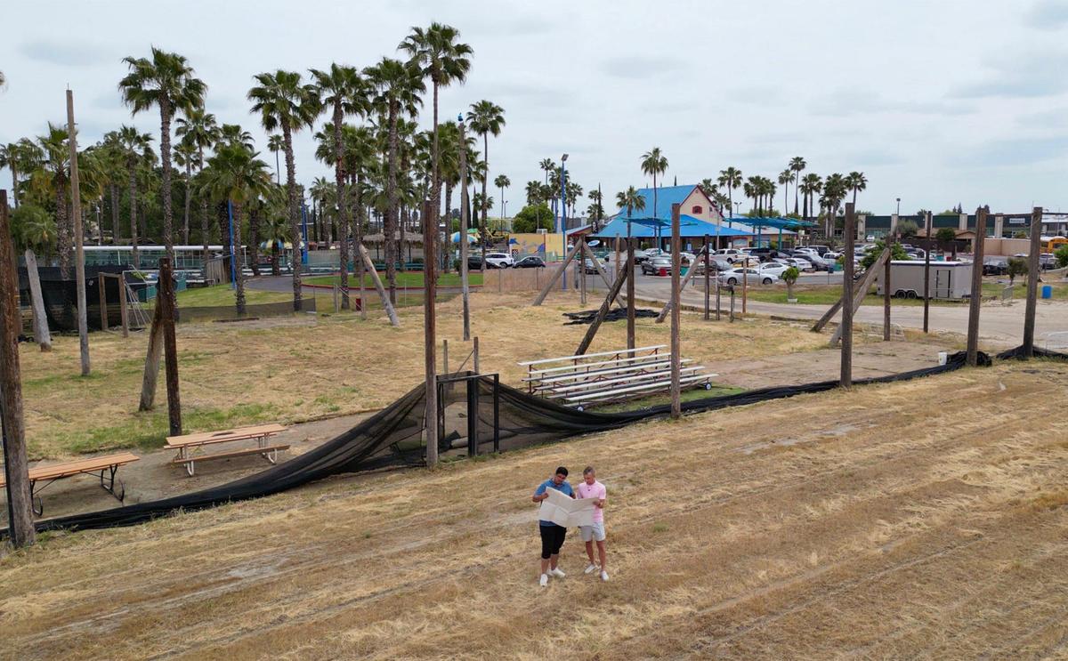 Juan Ruelas Jr., left, and Brian Easler, President of Fuego FC, stand in the former paintball field where they hope to build a new soccer stadium as they look over a map showing the property at Blackbeard’s Family Entertainment Center on Thursday, April 17, 2025 in Fresno.
