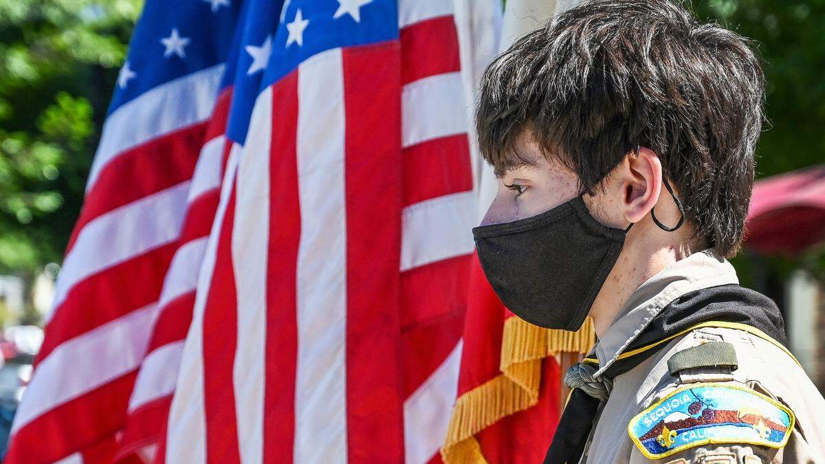 A member of the Boy Scouts Troop 257 of Clovis stands by a row of American flags during a Flag Day ceremony at Centennial Plaza in Clovis on Tuesday, June 14, 2022.
