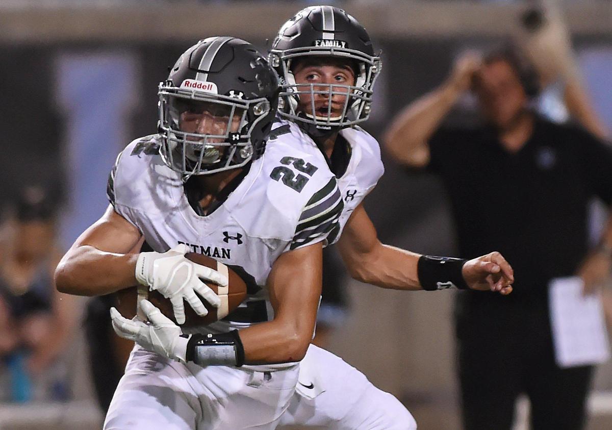 Pitman’s JullienLindo carries the ball, left, after handoff from quarterback Landyn Magina, right, Friday, Aug. 22, 2109 in Clovis. Clovis North shutout Turlock’s Pitman 27-0.