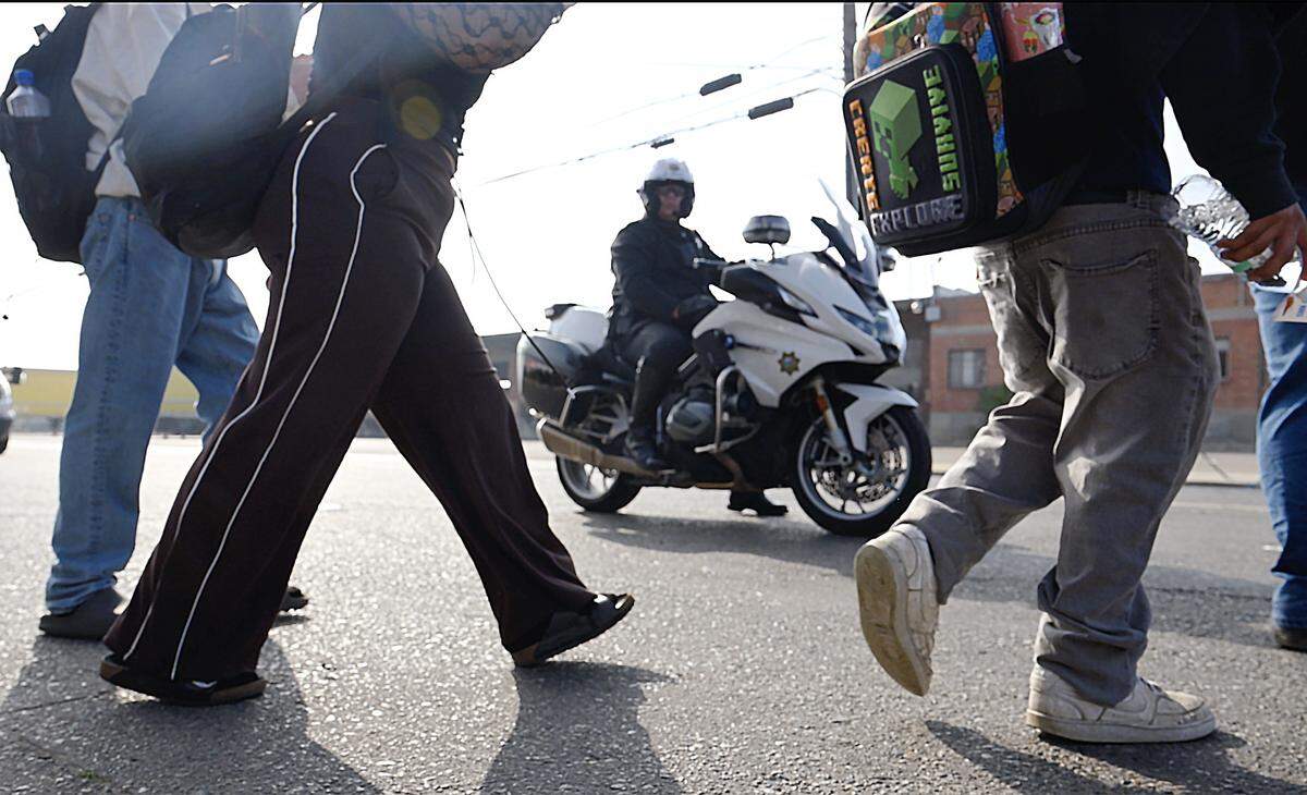 A Fresno police officer on motorcycle watches Washington Union students march to Fresno City Hall Monday, Feb 2, 2026 in Fresno.