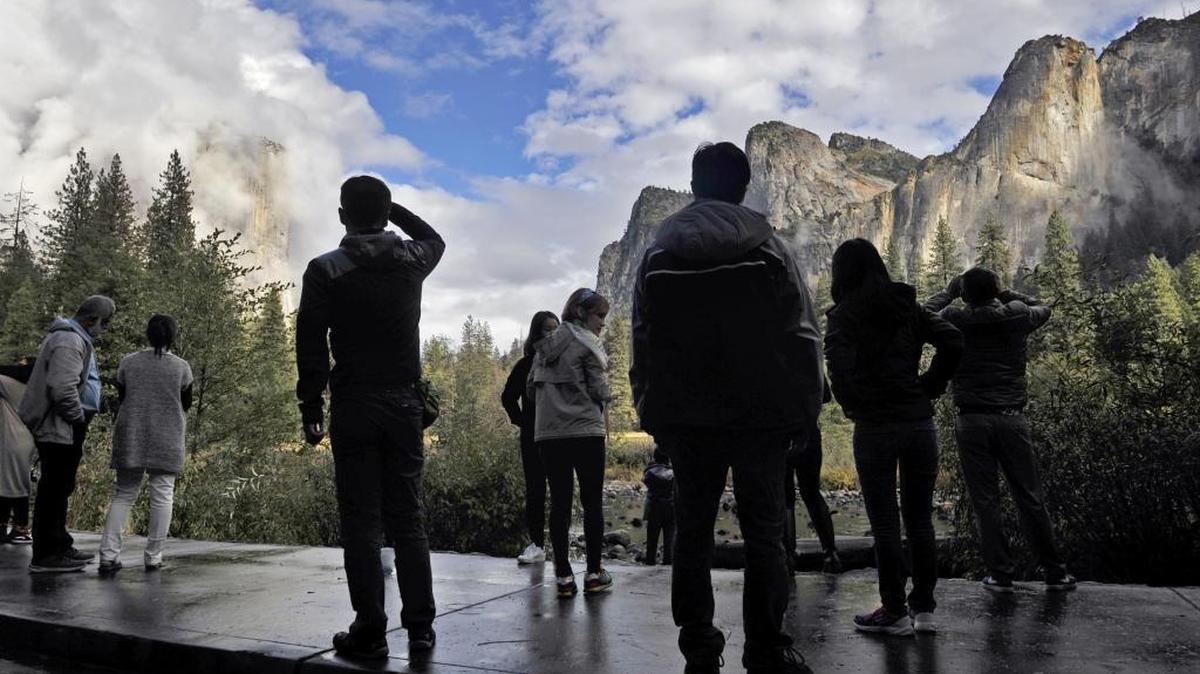 
Visitors to Yosemite Valley view clouds forming along the granite ridges following a rain storm in Yosemite National Park on Oct. 1.
