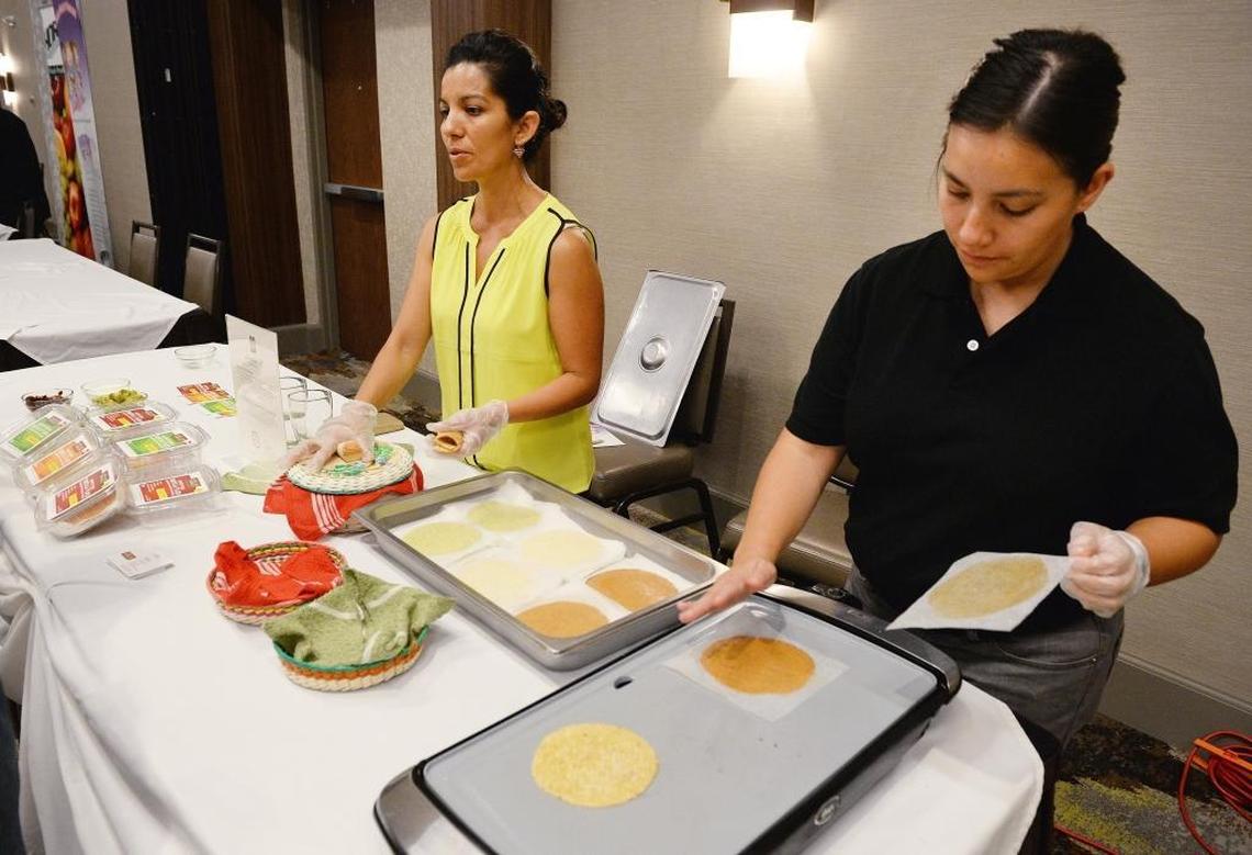 Liz Sanchez, left, and her sister Perla Sanchez of Casa de Tamales heat up their tortilla flats for tasting at a new-product event earlier this month. The company will also be at the expo itself Thursday, July 27.