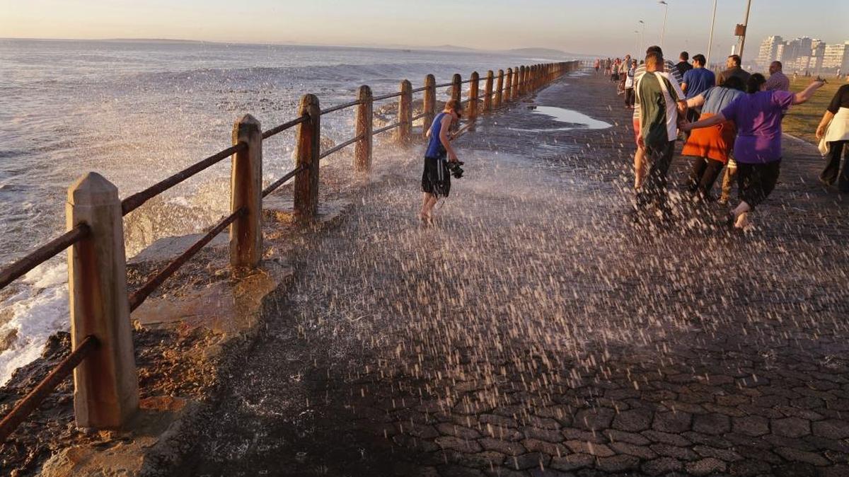 This Aug. 24, 2014 file photo shows a child sprayed by a wave on the promenade, a popular tourist hotspot near the city of Cape Town, South Africa. Cape Town is turning up on some lists for places to go in 2017, partly because exchange rates make it affordable and also because a new contemporary arts museum is opening in the fall.