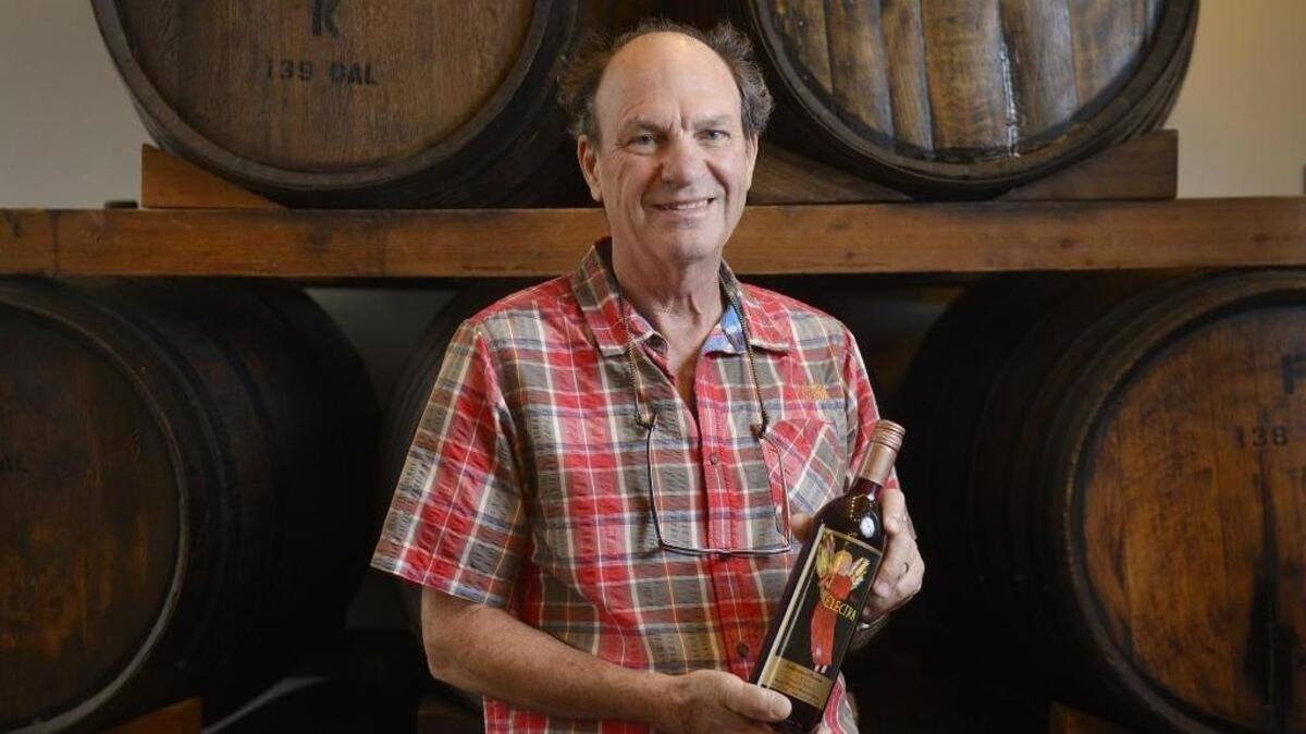 Andrew Quady of Quady Winery in Madera stands in the winery’s tasting room with a bottle of his popular Red Electra muscat wine.