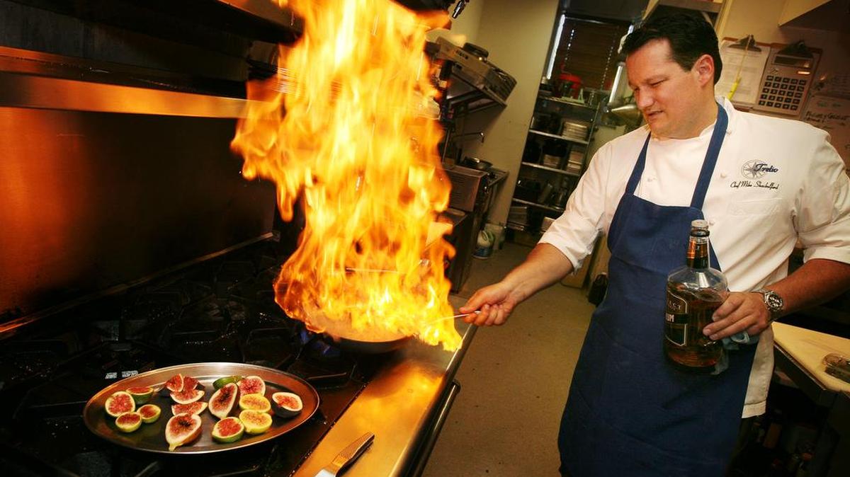 Flames erupt from a pan as Chef Mike Shackelford prepares figs Foster with a rum sauce at Trelio in Clovis in 2012. Figs are back in season and many area restaurants, including Trelio, are adding dishes to their menus.