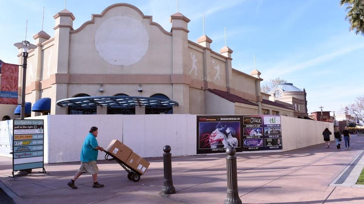 A delivery man pushes a stack of boxes past the former World Sports Cafe space at River Park shopping center in January 2017. JPot, a hot pot Asian restaurant, will be one of two restaurants moving into the space.