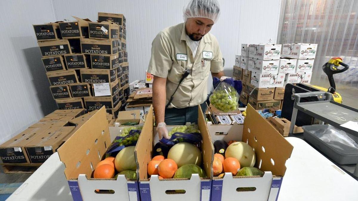 
Warehouse worker Luis Zaragoza demonstrates how workers pack weekly produce boxes for the Farms to Families program at 1st Quality Produce in Fresno. The produce wholesaler launched its concept of a community supported agriculture program last month with its Farm to Families program. Each box contains 10-15 California-grown produce items and costs between $22 to $29.99 depending on the quantity of boxes ordered.
