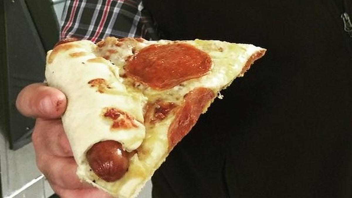 
Justin Dukes makes the Frankenslice, a slice of pizza with a hot dog rolled into its crust and baked in a smoker.
