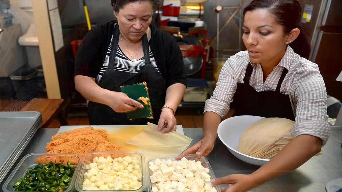 
Left to right, Carmen Martinez and Casa de Tamales owner Liz Sanchez prepare tamales using Mexican cheese at Casa de Tamales former location in 2013. Casa de Tamales has moved to its new location in the Tower District and opens at 609 E. Olive Ave. on Tuesday.
