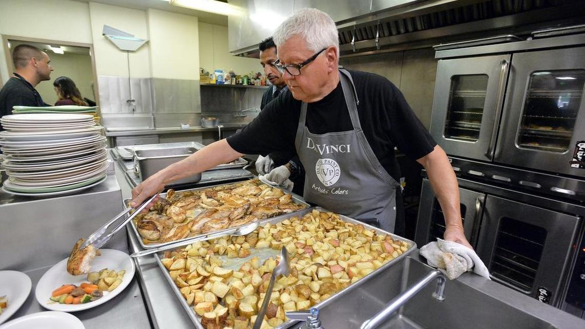 
Chef Roy Harland, 73, plates chicken with roasted potatoes and vegetables in the kitchen at Papa Mike’s Cafe at the Poverello House.
