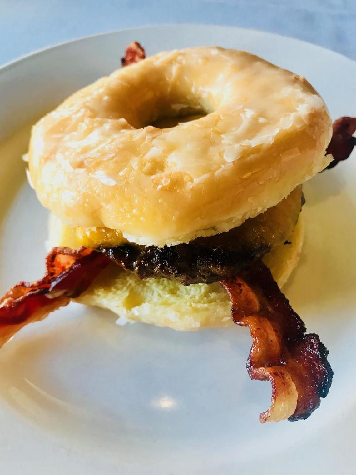 This doughnut burger made with a glazed doughnut split in half for a bun, a burger patty and two slices of bacon.