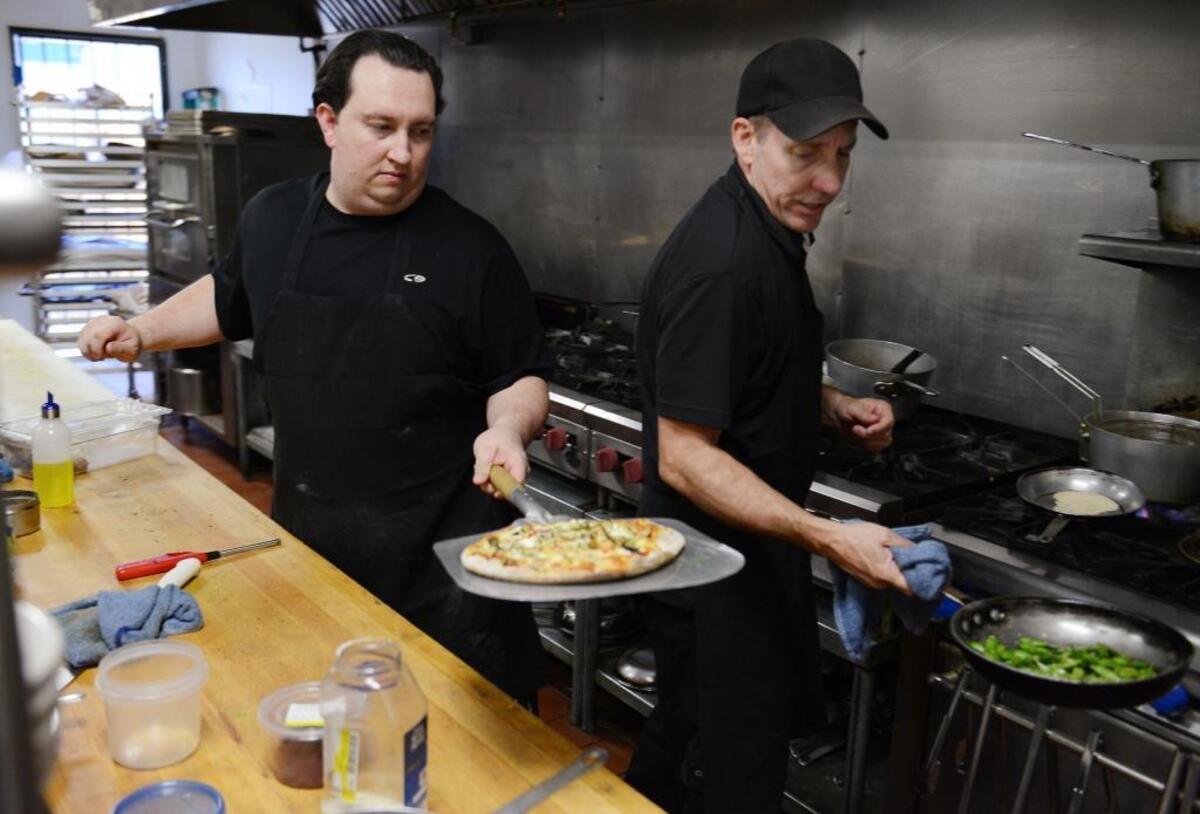 Chef Matt Babcock, right, and sous-chef Brent Pollock of Cafe Via work in the kitchen.
