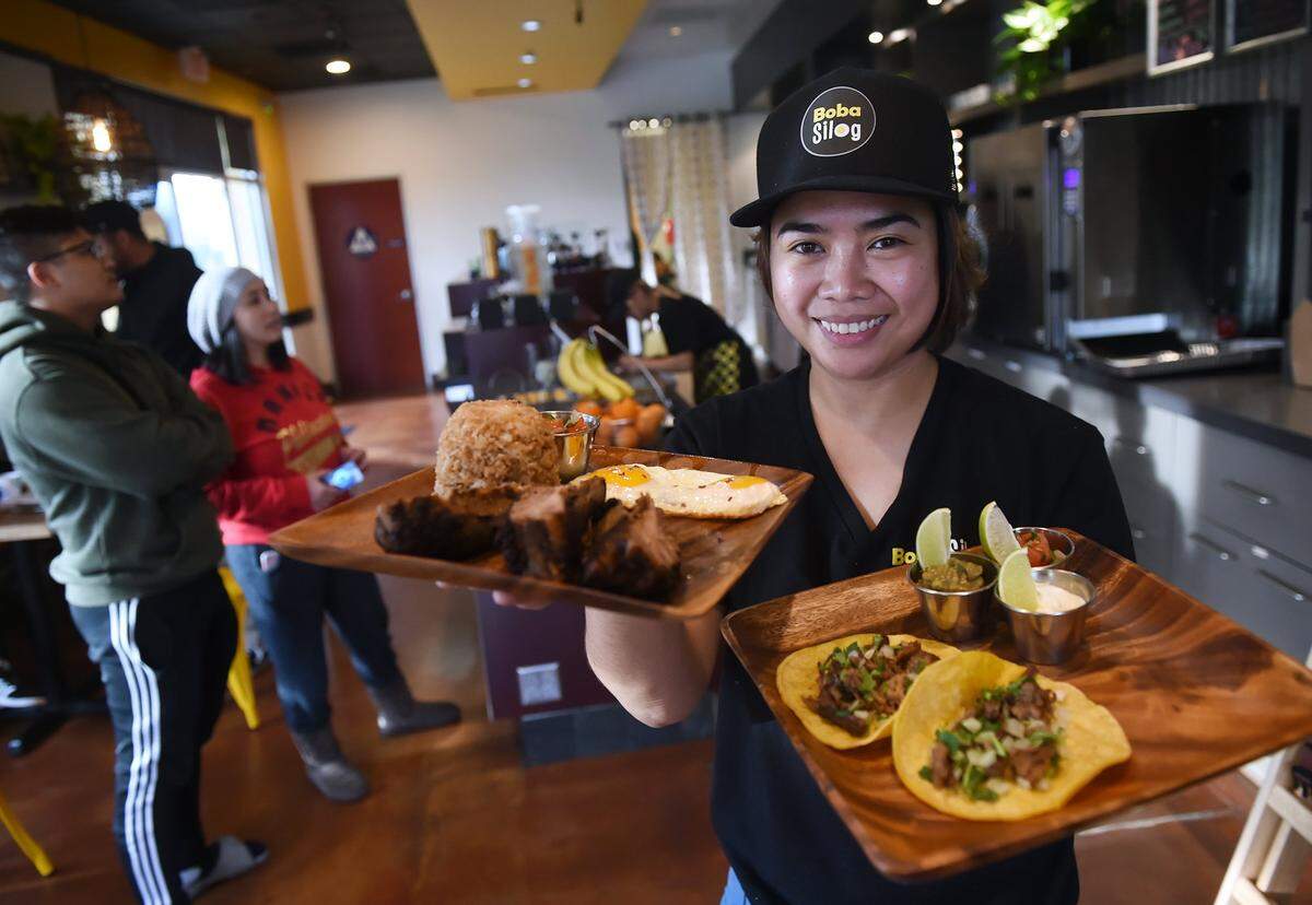 Jacque Abesamis, who co-owns Boba Silog with her sister, shows off the new Filipino-fusion restaurant’s adobo baby back ribs with garlic rice and eggs, and adobo tacos in this Fresno Bee file photo from 2019.