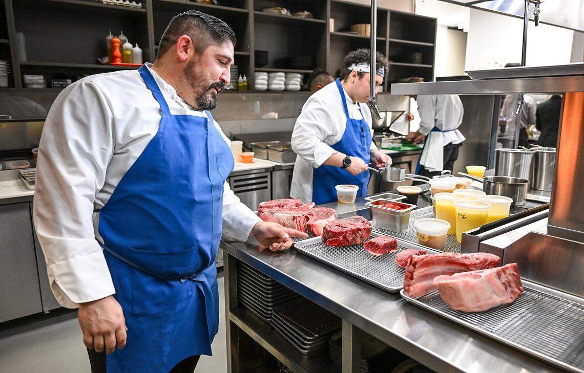 Grill cook Kevin New check on a selection of dry-aged meats before grilling at Bulle, a new high-end restaurant in northwest Fresno on Tuesday, April 23, 2026.