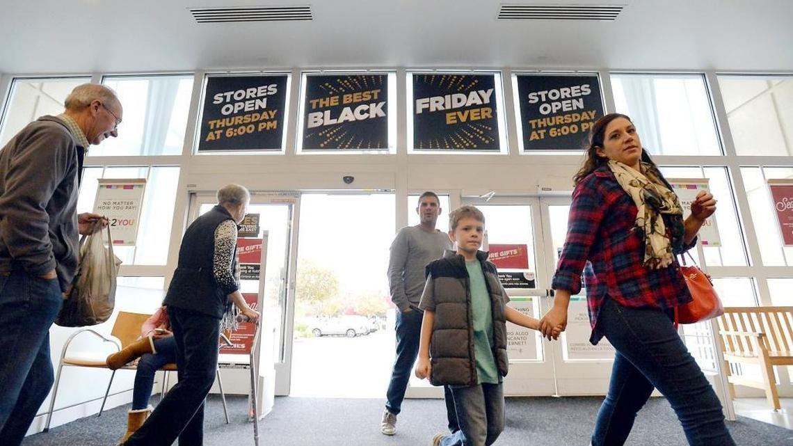 Customers walk past Black Friday sale sign on display at the front entrance at the Kohl’s department store on Tuesday, Nov. 24, in north Fresno.