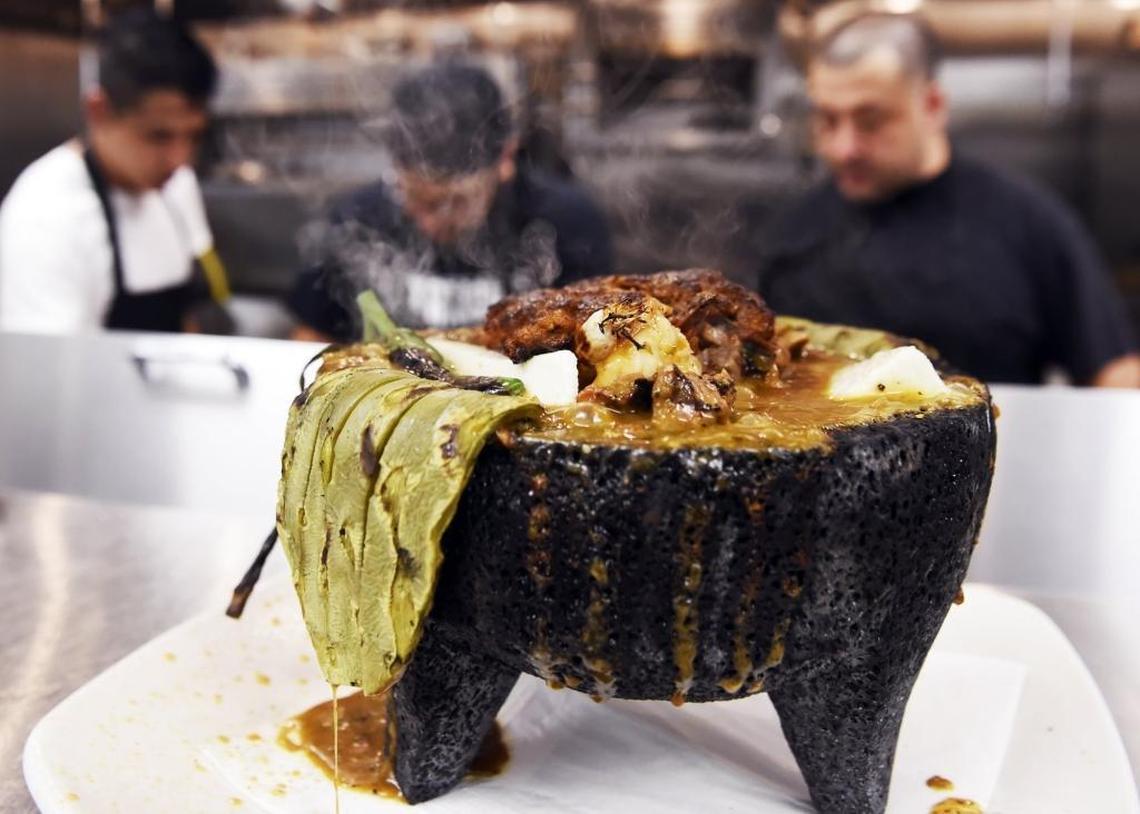 The sizzling Molcajete is a featured dish with roasted nopales, chiles toreados, grilled onion and chorizo in a Yucatan green sauce topped with queso fresco in a lava rock molcajete, served with fresh corn or flour tortillas at the newly opened Que Pasa! in Campus Pointe just east of Fresno State.