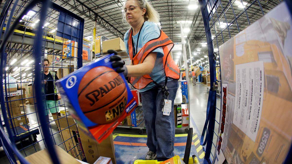 In this Dec. 1, 2014 photo, Teresa Clark fills an order at the Amazon fulfillment center on Cyber Monday, in Lebanon, Tenn. Retailers have been pushing back shipping deadlines and extending free shipping offers, putting more pressure package carriers. Amazon extended its free-shipping deadline by one day to Dec. 19.