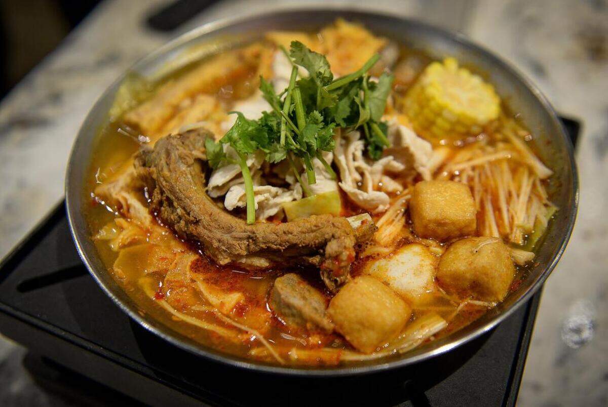 The J Pot is a hot pot that includes spare ribs, fried tofu, iced tofu, tofu skin, fish ball, calamari, beef meatball, clam, quail egg, beef tripe, cabbage, fried taro, enoki mushrooms, corn, ramen noodles, cilantro and served “crazy spicy” at the new J Pot restaurant in the River Park shopping center.