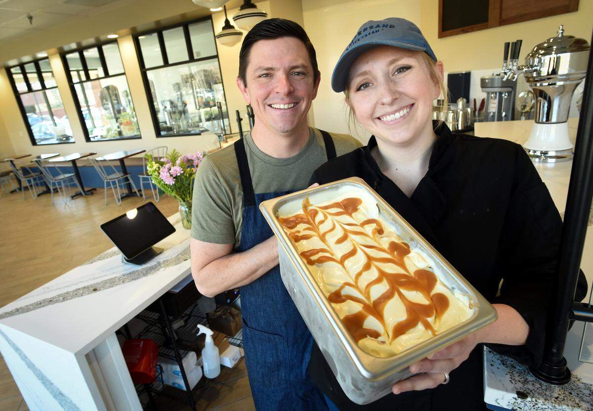 Ampersand Ice Cream shop owners Jeff and Amelia Bennett hold a fresh batch of their whiskey caramel swirl ice cream at their Herndon and Marks avenues location in this 2019 file photo. The couple is planning a third location, this one at The Row at Heritage Grove.
