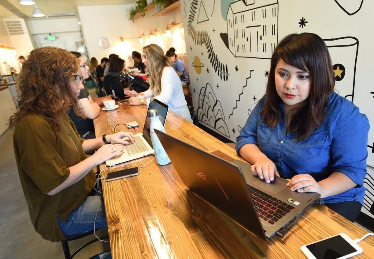 Michah Garcia, right, prepares for her podcast “Dreamers That Do,” at Hi-Top Coffee shop in the Tower District in this file photo from 2017.