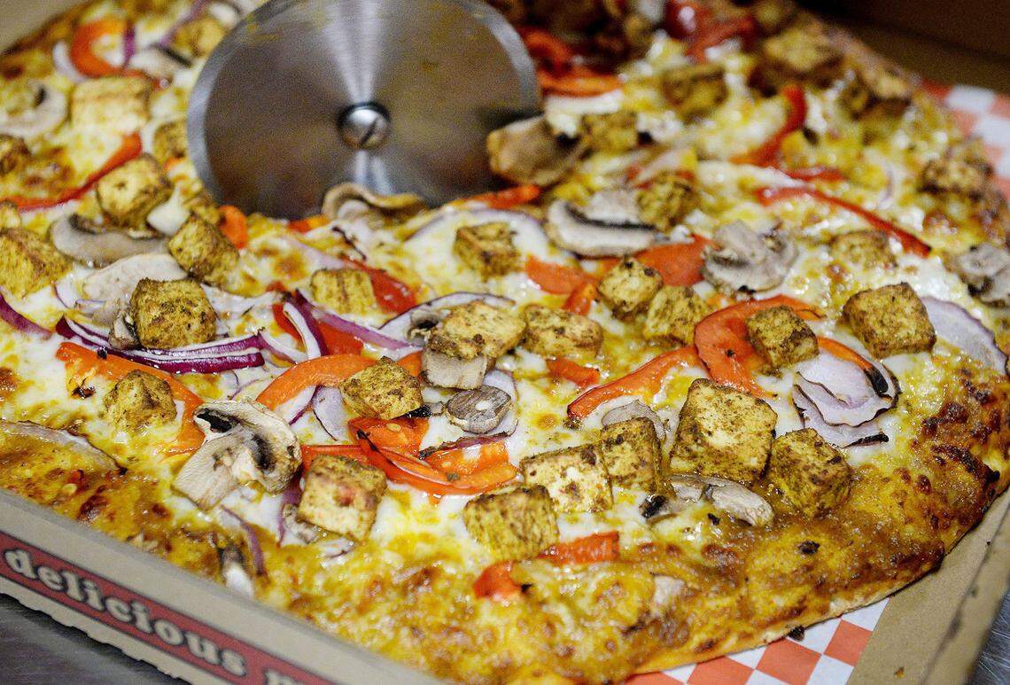Malhi Singh of The Curry Pizza Company slices up a butter paneer pizza to go at the restaurant in Fresno on Thursday, June 7, 2018.