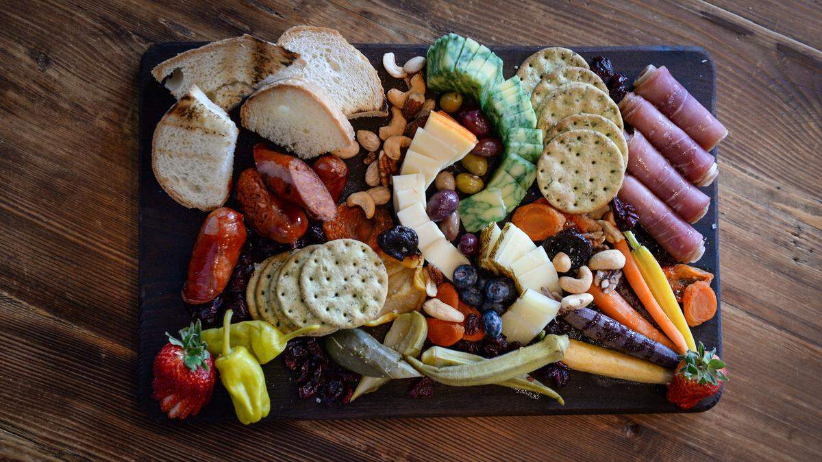 Charcuterie boards like the Local Board, featuring California-sourced fresh seasonal cheese, meats, veggies and fruits, are listed as sharable boards at The Local, where a community atmosphere is part of the ambiance.