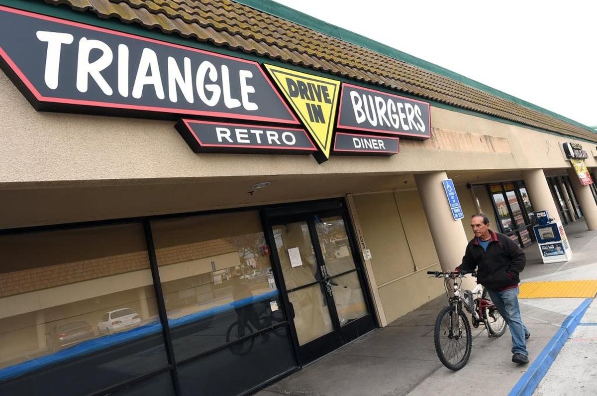 Sergio Hinojosa, walking his bike, looks forward to the opening of Triangle Burgers Drive In, 200 W. Shaw Ave. in Clovis.