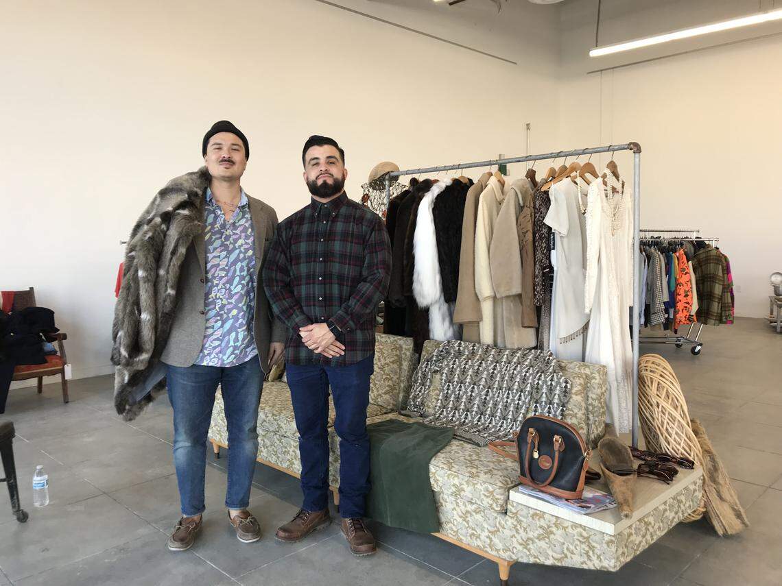 Neighbhorhood Industries executive director Anthony “AP” Armour and development director Ricky Bravo stand amid the vintage clothing and furniture for sale at blkmktplc.